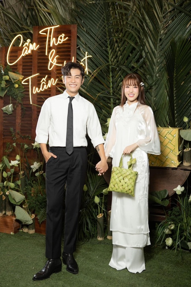 Puka diện áo dài chất liệu lụa nền nã. Cô cầm túi xách làm bằng lá dừa. Gin Tuấn Kiệt diện sơ mi trắng và quần tây bảnh bao.