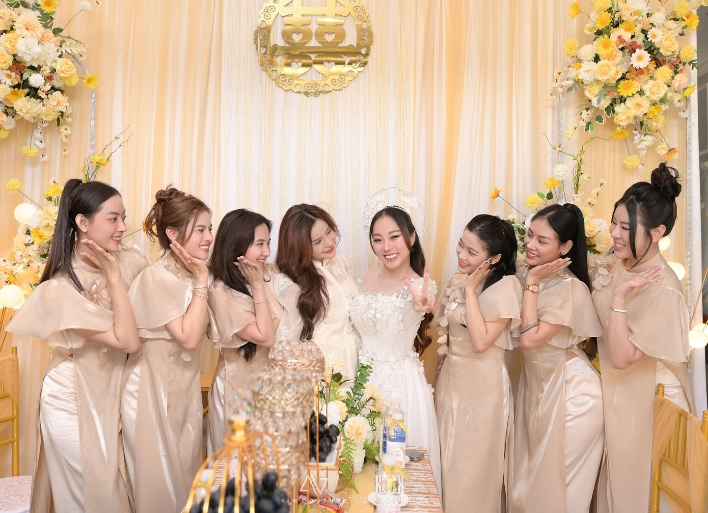 Tuyết Nhung và đội phù dâu tươi tắn trước khi đón tiếp nhà trai. Đội nhà gái mặc áo dài đồng điệu, làm nổi bật cô dâu trong áo dài trắng, mấn đội đầu cách điệu.