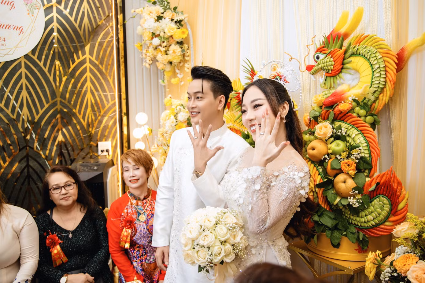Cô dâu và chú rể khoe nhẫn cưới trước quan viên hai họ. Cô dâu và chú rể khoe nhẫn cưới trước quan viên hai họ.