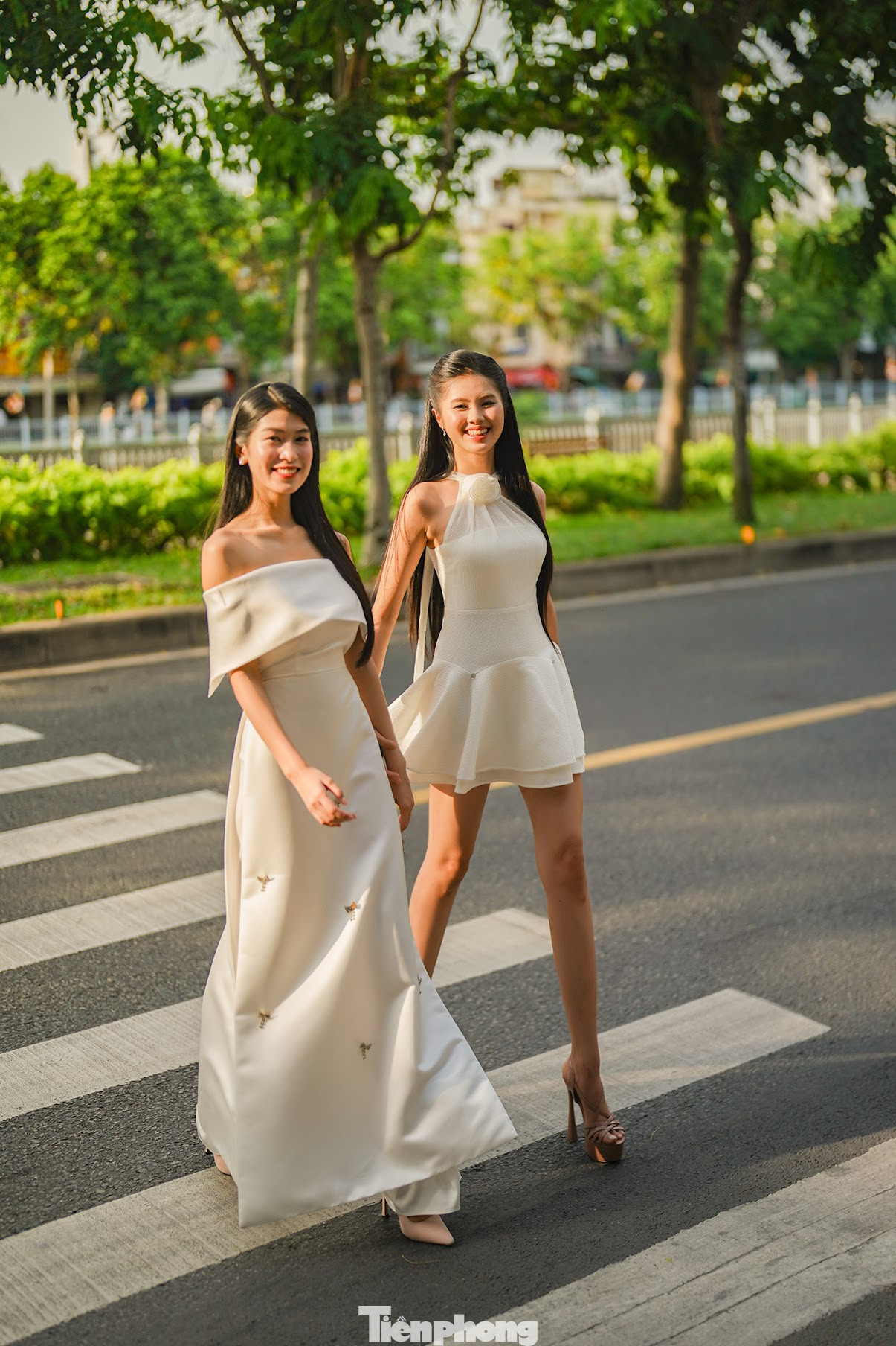 Hai cô gái thuộc top 25 Hoa hậu Việt Nam 2024 thu hút ánh nhìn của người dân khu vực đường Hoàng Sa nhờ vóc dáng, gương mặt rạng rỡ.