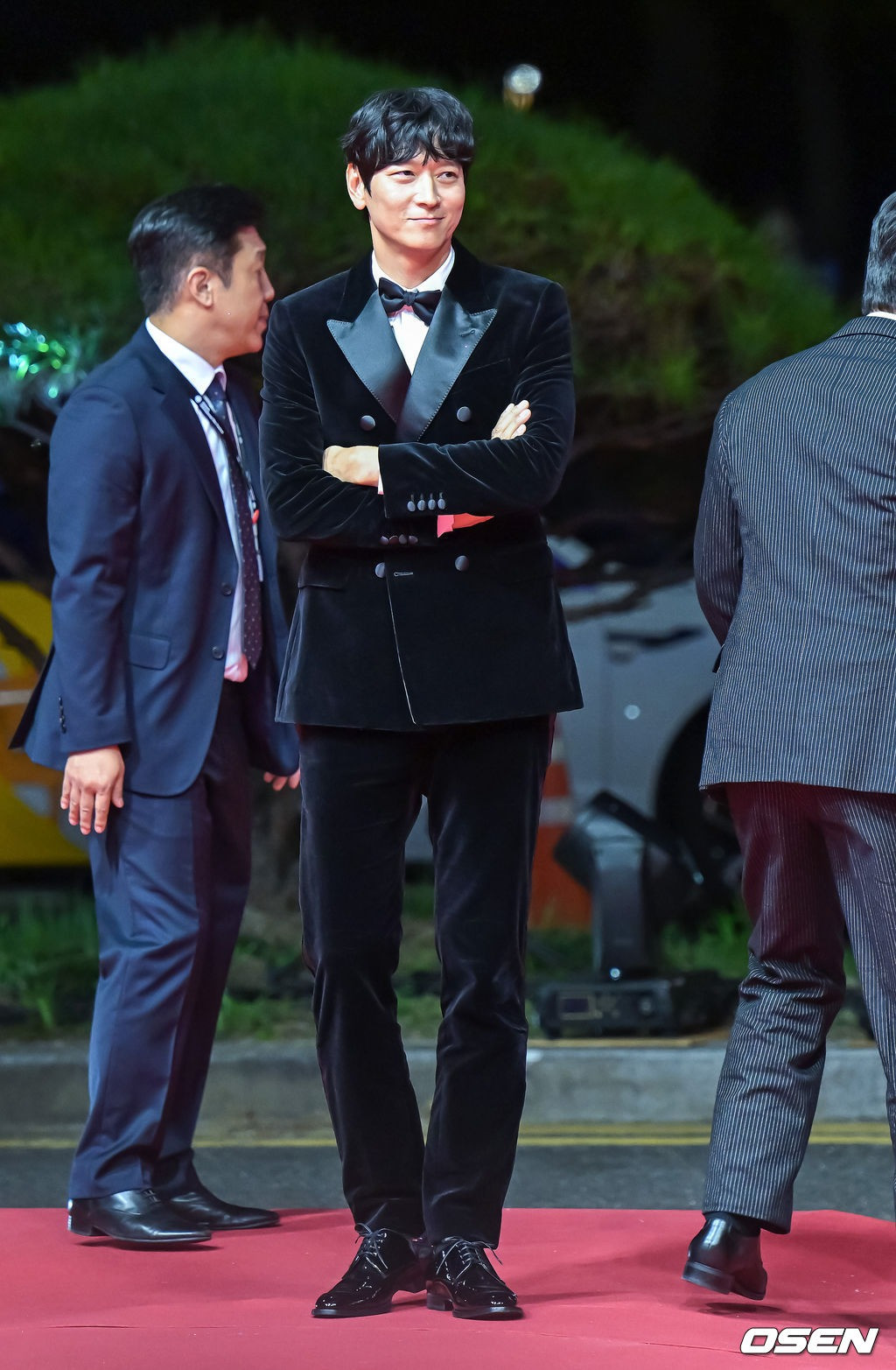 Tài tử Kang Dong Won tạo điểm nhấn bằng cách tạo dáng hài hước trên thảm đỏ. Kiểu tóc uốn nhẹ, che phủ phần trán giúp diễn viên Bán đảo trông trẻ trung hơn so với tuổi 43 tuổi.