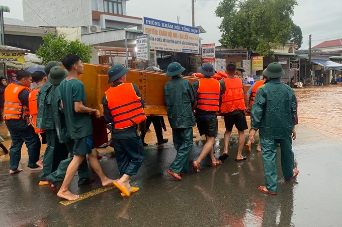 Lực lượng huyện đội, công an đến hiện trường ngập lụt hỗ trợ di chuyển tài sản giúp người dân (Ảnh: C.L.).