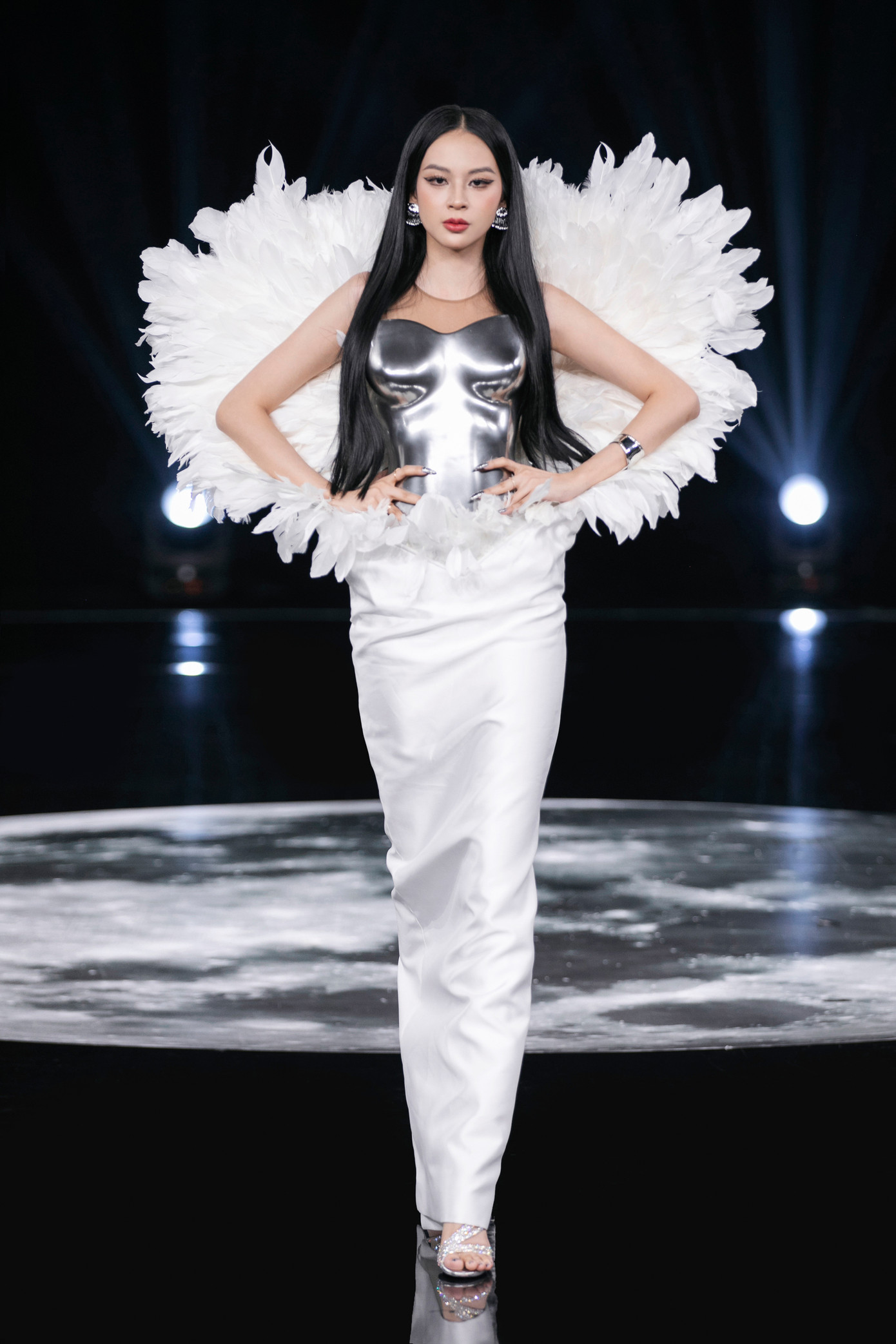 Bộ trang phục của Phí Phương Anh đối lập giữa chi tiết áo giáp kim loại và chi tiết lông vũ cầu kỳ phía sau. Bộ trang phục của Phí Phương Anh đối lập giữa chi tiết áo giáp kim loại và chi tiết lông vũ cầu kỳ phía sau.