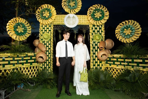 Cổng hoa được trang trí thủ công bằng lá dừa trông hoàng tráng, đẹp mắt. Chia sẻ với Tiền Phong, ê-kíp của Gin Tuấn Kiệt và Puka cho biết đám cưới có mặt đội vệ sĩ kết hợp dân phòng địa phương nhằm đảm bảo riêng tư và an toàn cho khách mời di chuyển ra vào nhà cô dâu.