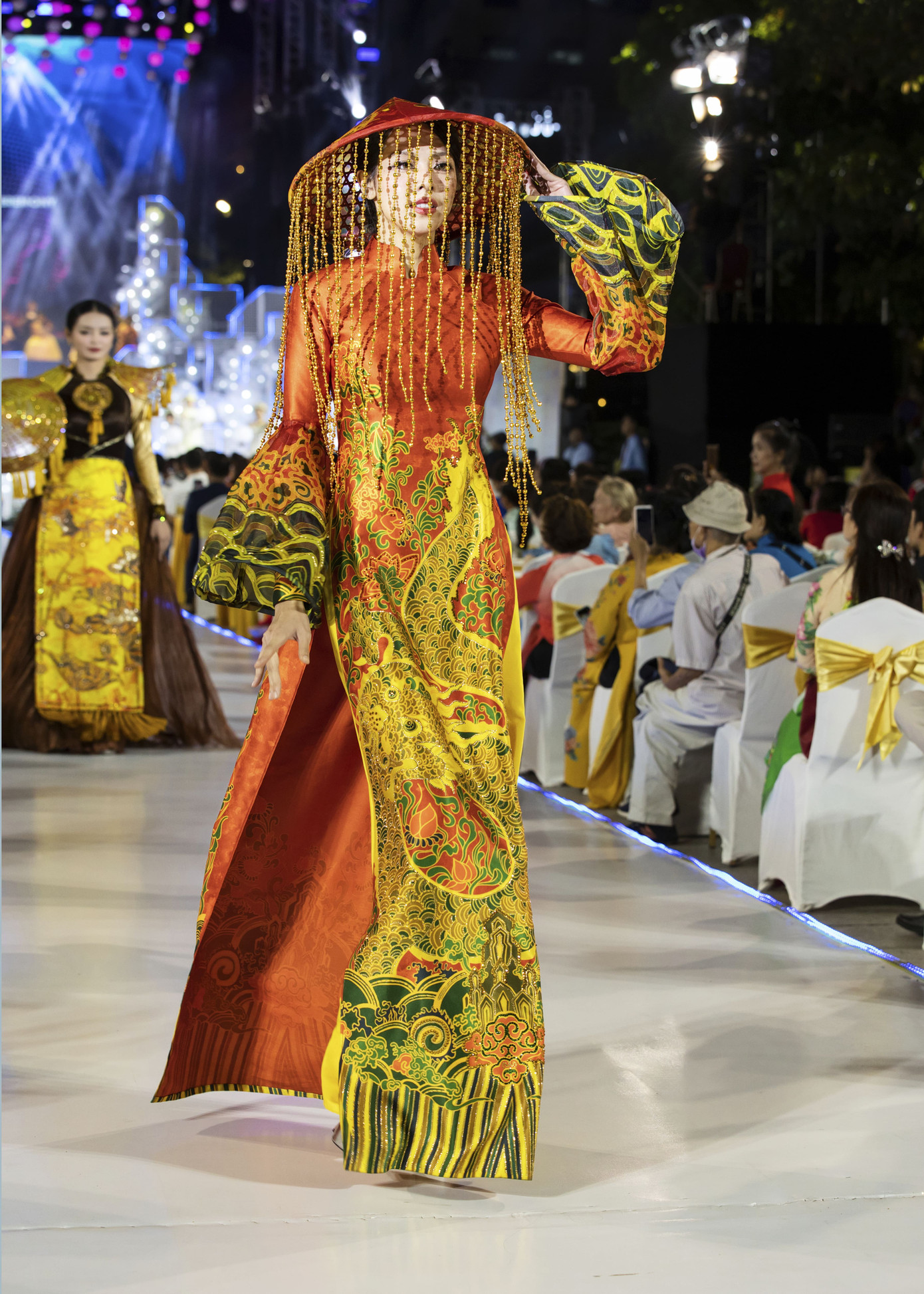 Thiết kế độc đáo ở điểm kết hợp áo dài với nón lá với hàng chuỗi tua rua. Đây cũng là trang phục được Miss Grand International Isabella Memin diện khi quảng bá Hoa hậu Hòa bình Quốc tế được đăng cai tại Việt Nam năm 2023.