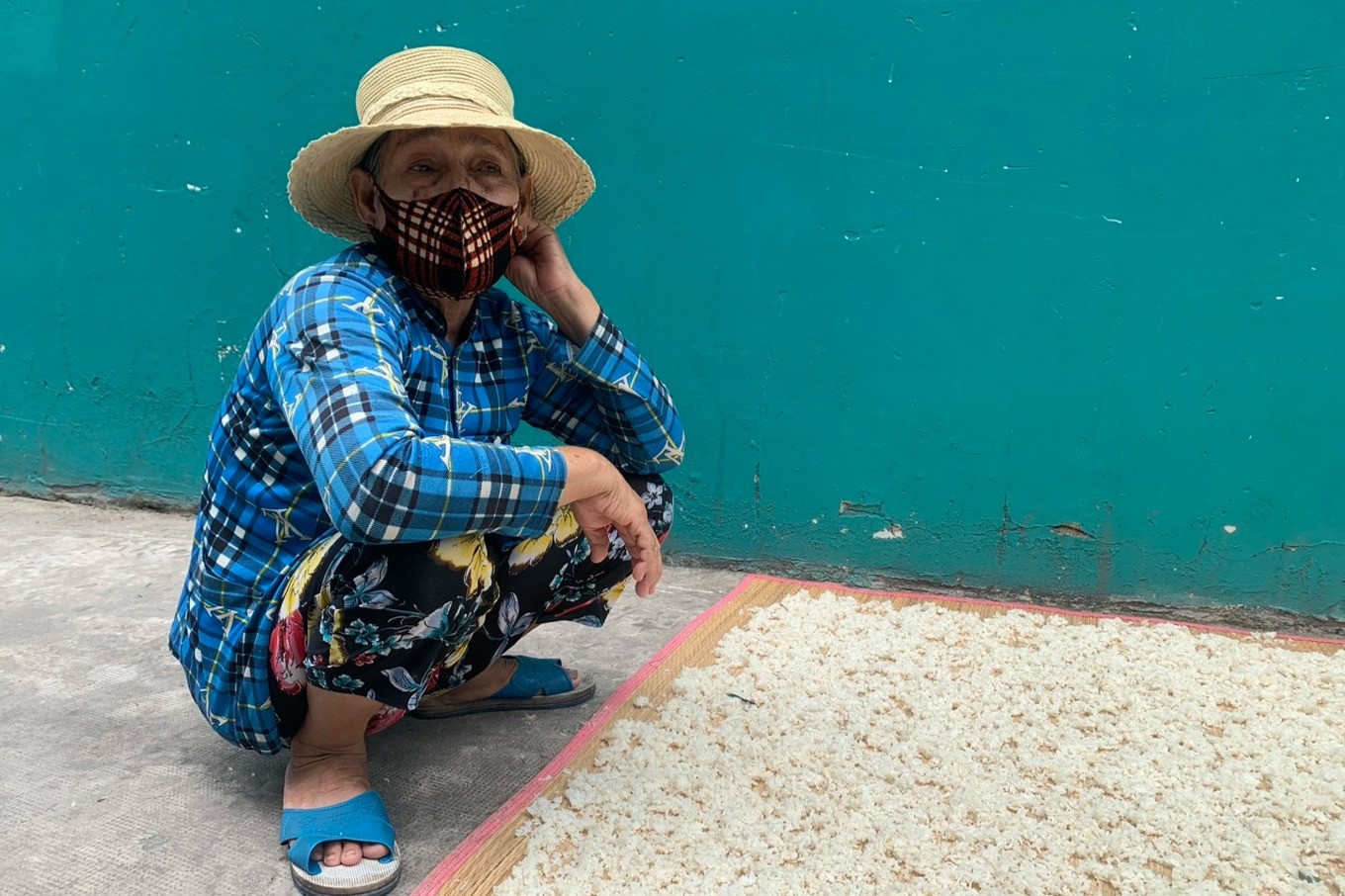 May mắn hơn nhiều công nhân khác, con trai bà Nguyễn Ngọc Điệp (67 tuổi, quê An Giang) vẫn còn việc làm (công nhân bảo trì) nhưng cũng chỉ còn làm 5 ngày/tuần nên thu nhập bị giảm. Để hỗ trợ con, bà Điệp phơi cơm khô bán kiếm thêm, phụ giúp tiền ăn (Ảnh: Phạm Diện).