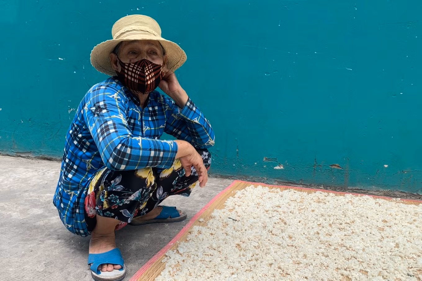 May mắn hơn nhiều công nhân khác, con trai bà Nguyễn Ngọc Điệp (67 tuổi, quê An Giang) vẫn còn việc làm (công nhân bảo trì) nhưng cũng chỉ còn làm 5 ngày/tuần nên thu nhập bị giảm. Để hỗ trợ con, bà Điệp phơi cơm khô bán kiếm thêm, phụ giúp tiền ăn (Ảnh: Phạm Diện).