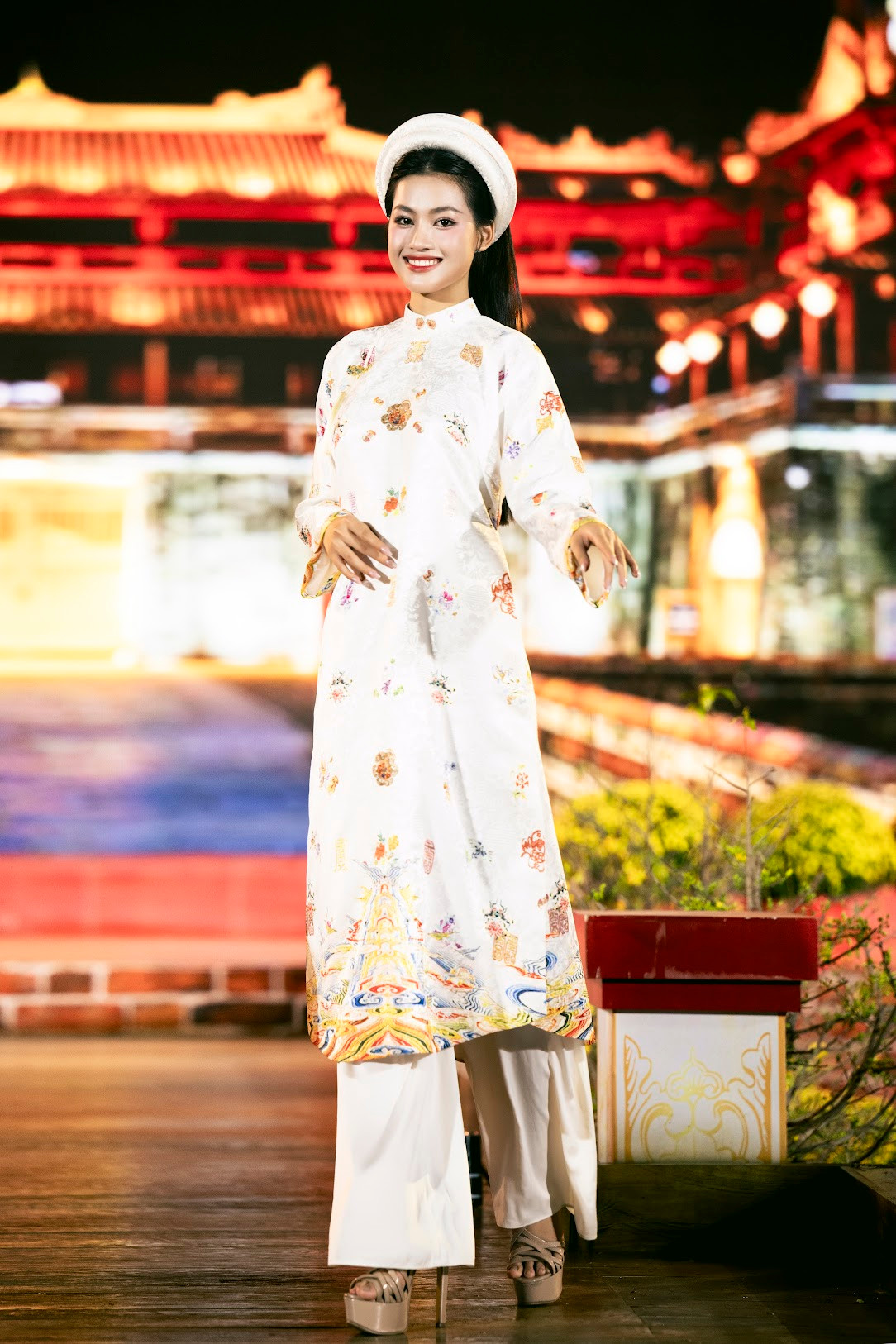 Á hậu Minh Thư mang lại phong cách duyên dáng, nền nã khi thể hiện hình ảnh cô gái Huế trong tà áo dài trắng in họa tiết cung đình Huế.