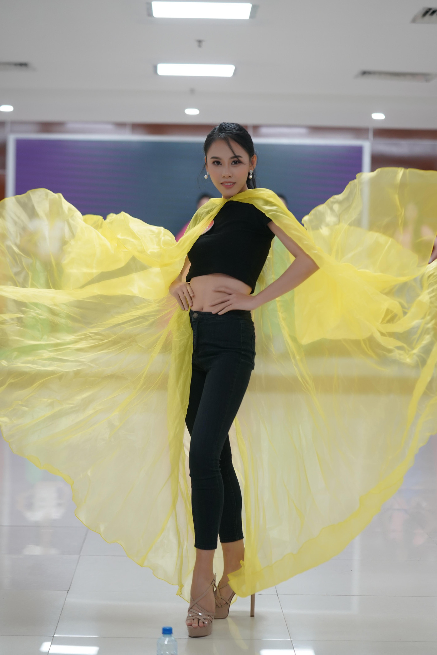 Thí sinh Lê Nguyễn Ngọc Hằng (SBD 166) diện crop top khoe vòng eo đến buổi huấn luyện nâng cao cùng huấn luyện viên chuyên môn. Cô chọn cách xử lý tà áo bồng bềnh tạo thành hình vòng cung lớn.