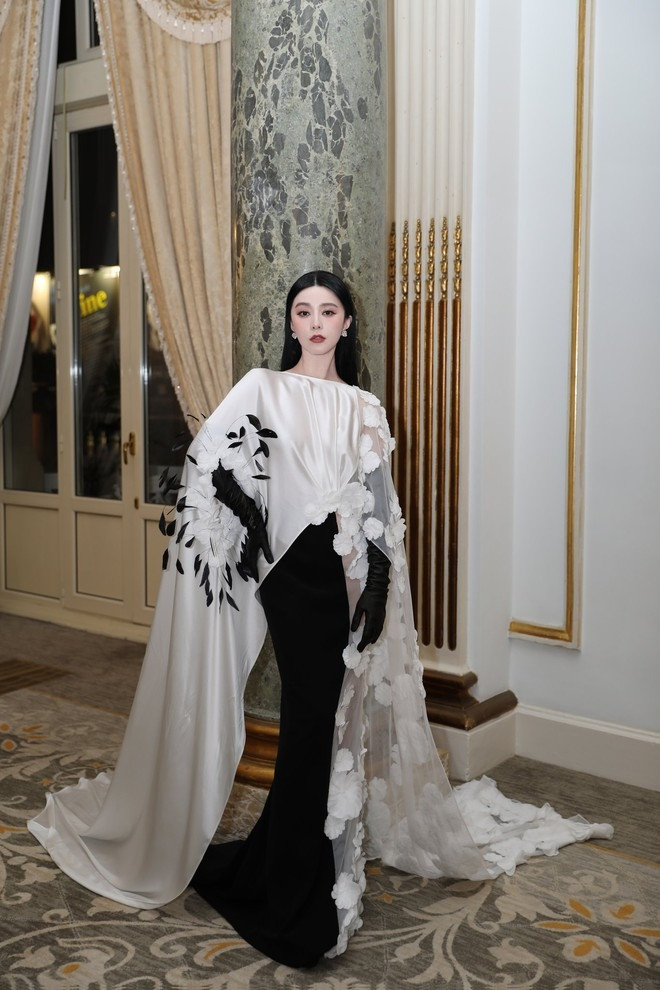 Trên thảm đỏ, cô diện đầm lụa phối hai màu hồng nhạt và đen. Chi tiết voan phần tay áo, đính kèm hoa 3D tạo tổng thể cầu kỳ, đi kèm là phần hoa gắn lông vũ, chi tiết bao tay ren...