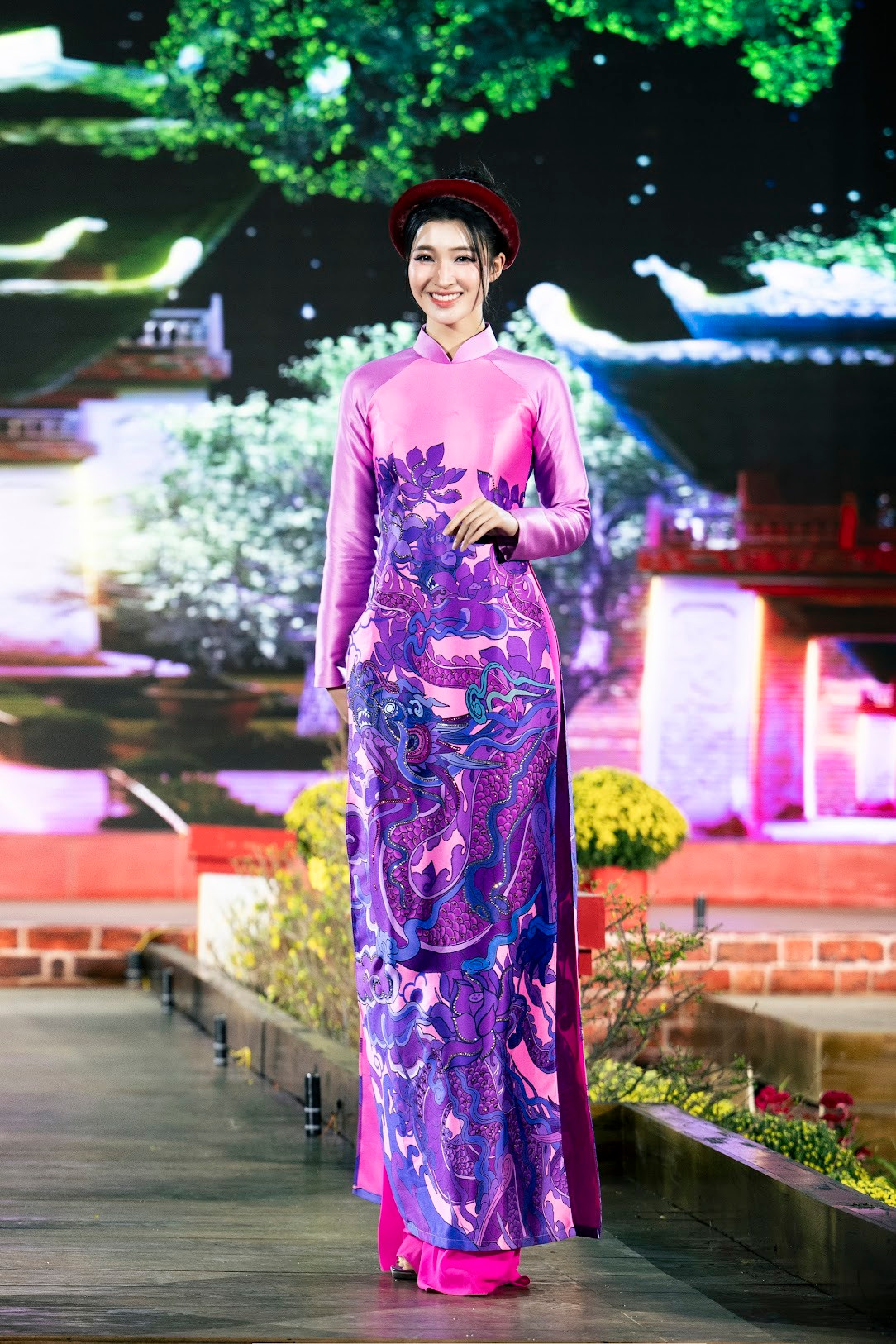 Á hậu Phương Nhi mặc áo dài chất liệu lụa in hoa văn rồng, mang lại cảm giác sang trọng.