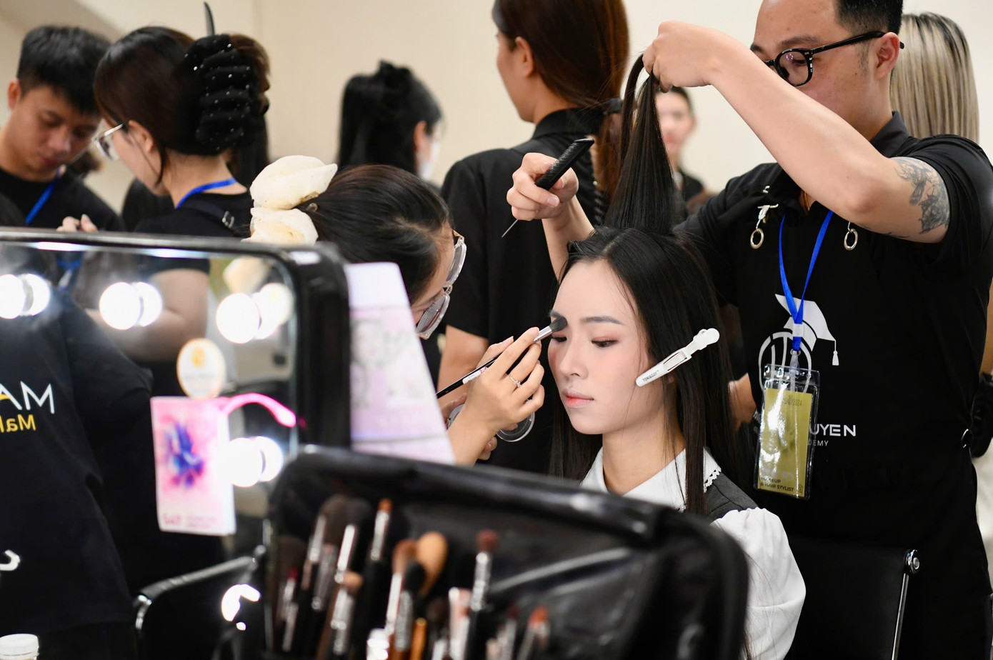 Thí sinh Hồng Duyên tập trung trong lúc được chuyên gia hỗ trợ trang điểm và làm tóc.