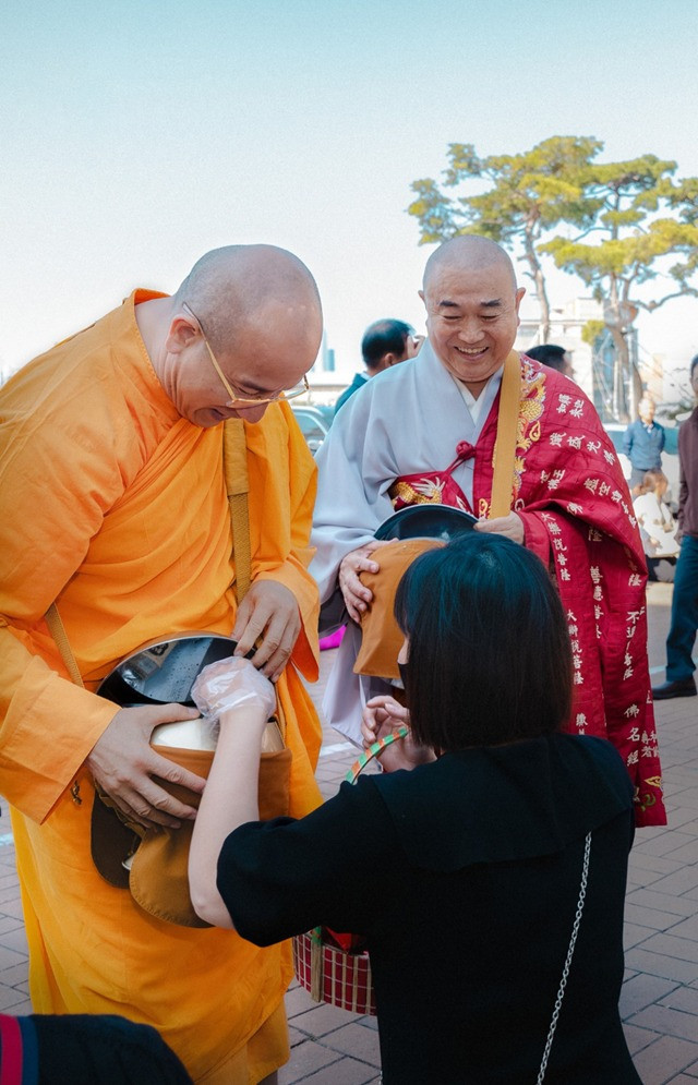 Thầy Thích Trúc Thái Minh cùng thầy Kim Do Won đi khất thực.