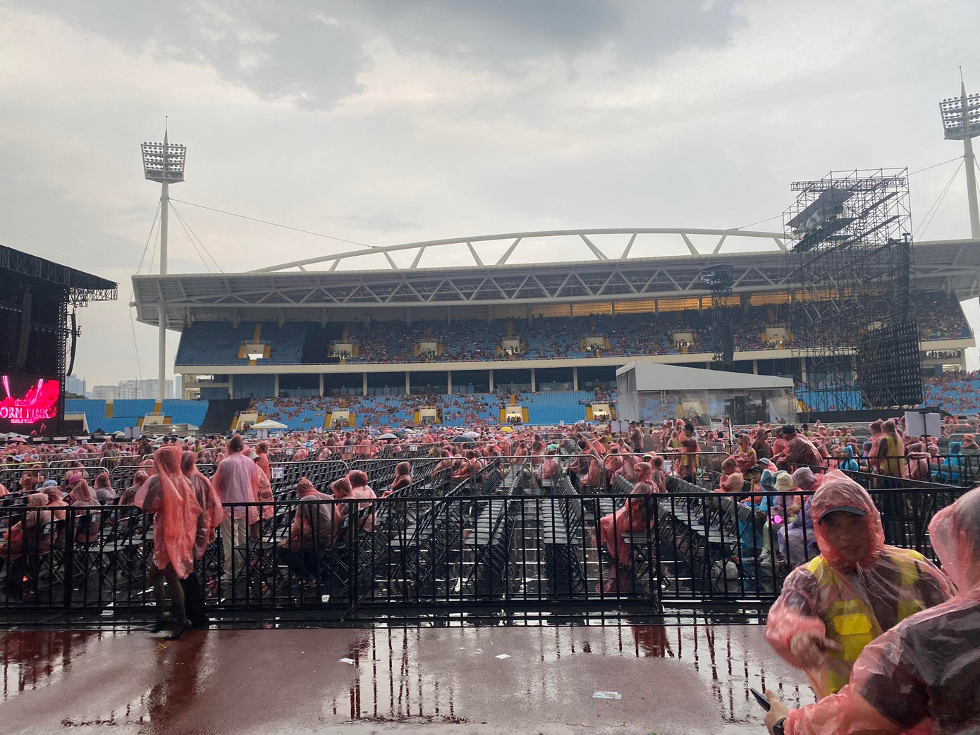 Theo ghi nhận của phóng viên Tiền Phong tại hiện trường, trời bắt đầu tạnh mưa lúc hơn 18h30, khán giả vào sân đông hơn, trước đó có nhiều người bất chấp mưa, mặc áo mưa vào ngồi đúng hàng, mong không lỡ cơ hội gặp thần tượng.