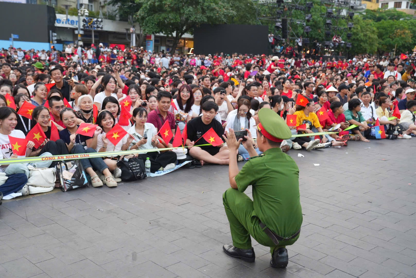 Chiến sĩ cảnh sát giữ trật tự cùng người dân chờ đợi đoàn diễu binh, diễu hành đi ngang. Khu vực trung tâm quận 1, TPHCM chật ních người nhưng hoàn toàn tuân thủ quy tắc an toàn, đồng lòng hướng về lễ kỷ niệm 50 năm Ngày Giải phóng miền Nam, thống nhất đất nước.