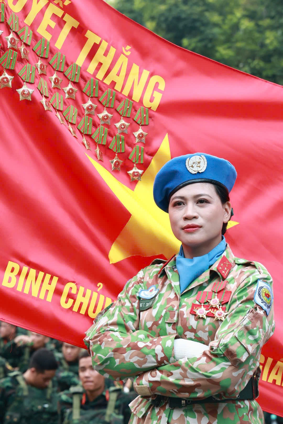 Khoảnh khắc nữ quân nhân thuộc Khối nữ gìn giữ hòa bình Liên Hợp Quốc (trái) và quân nhân thuộc Khối nữ sĩ quan Thông tin trước lá cờ Quyết thắng, thể hiện sự tự hào khi nằm trong đội ngũ lực lượng Quân đội Nhân dân Việt Nam.