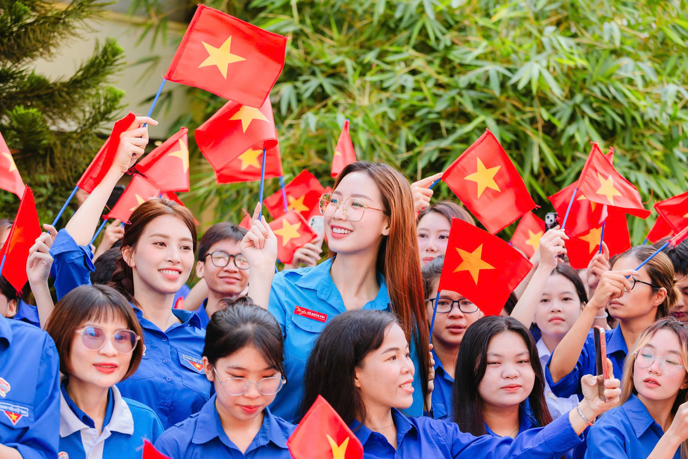 Hoa hậu Bảo Ngọc và Tiểu Vy hòa vào không khí tự hào cùng thành viên hội Liên hiệp Thanh niên Việt Nam, giơ cao lá cờ đỏ sao vàng tại Lễ chào cờ &quot;Tôi yêu Tổ quốc tôi&quot;.