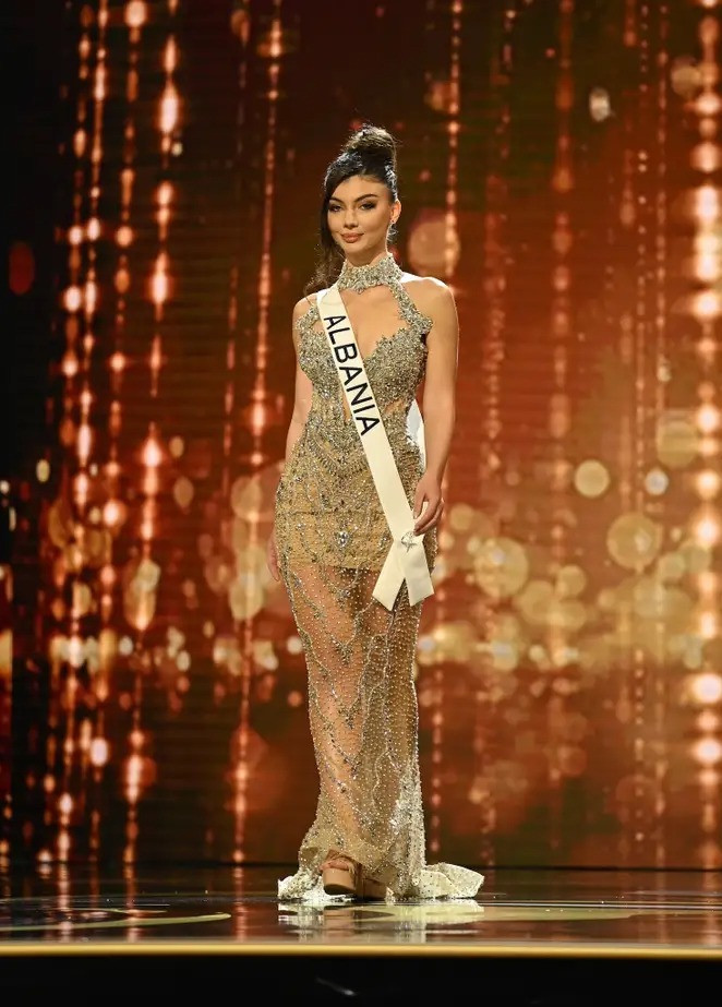 Deta Kokomani sử dụng váy xuyên thấu trên sân khấu Hoa hậu Hoàn vũ. Đại diện Albana gây chú ý với thiết kế cổ cao, đường cắt cúp táo bạo. Điểm nhấn của trang phục là chi tiết hạt lấp lánh bao quanh phần thân dưới.
