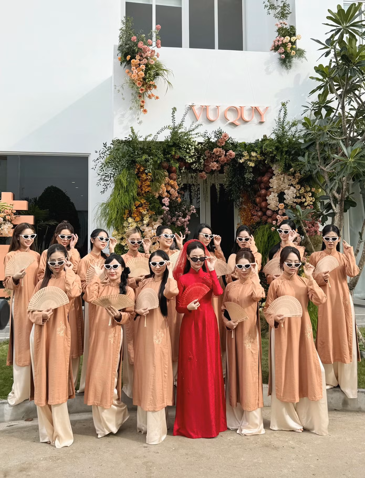 Midu và dàn phù dâu tạo dáng "ngầu" với kính mát, tay cầm quạt tre trước cửa nhà.
