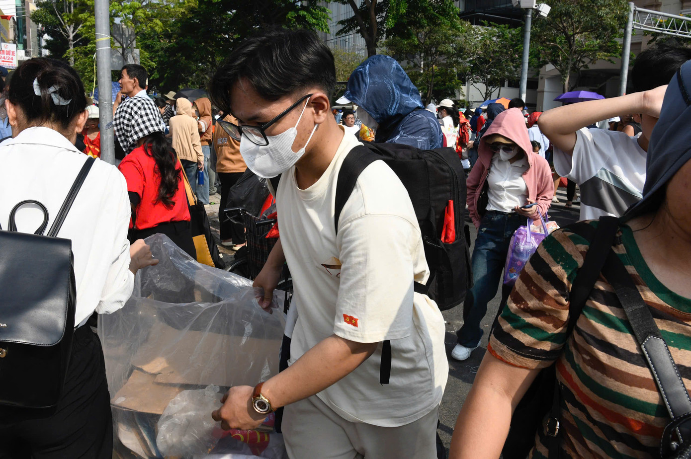 Người dân tản ra sau lễ để lại cảnh tượng nhiều rác, trong khi các bạn trẻ cặm cụi thu dọn từng ghế nhựa, bao bì và thức ăn bỏ lại.