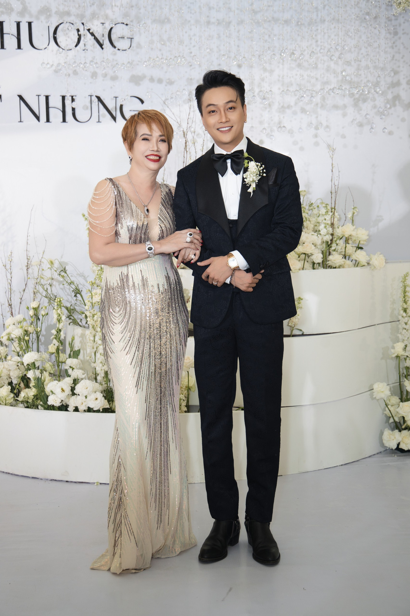 Mẹ ruột TiTi cười tươi, mặc sang trọng trong ngày vui của con trai. Tại đám hỏi ở Cần Thơ, bà tặng cho con trai và con dâu sính lễ gồm hoa tai, dây chuyền, nhẫn kim cương, tiền mặt 10.000 USD, ba cây vàng 9999. Mẹ ruột TiTi cười tươi, mặc sang trọng trong ngày vui của con trai. Tại đám hỏi ở Cần Thơ, bà tặng cho con trai và con dâu sính lễ gồm hoa tai, dây chuyền, nhẫn kim cương, tiền mặt 10.000 USD, ba cây vàng 9999.