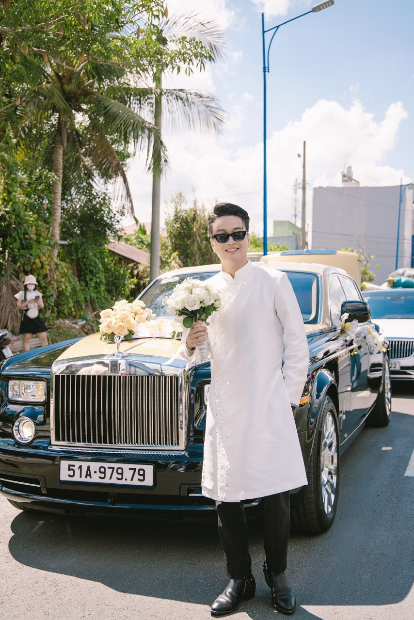 Chú rể chụp ảnh bên xe sang trước khi bước vào nhà cô dâu làm lễ.