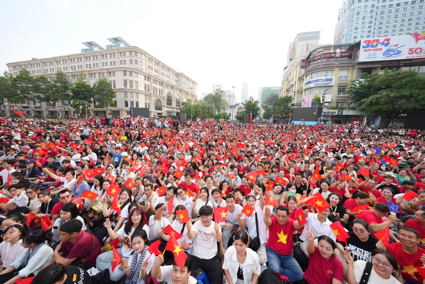 Khu vực trung tâm quận 1, TPHCM ngập sắc đỏ. Người dân ngồi chỉnh tề, liên tục reo hò khi đoàn diễu binh, diễu hành đi qua.