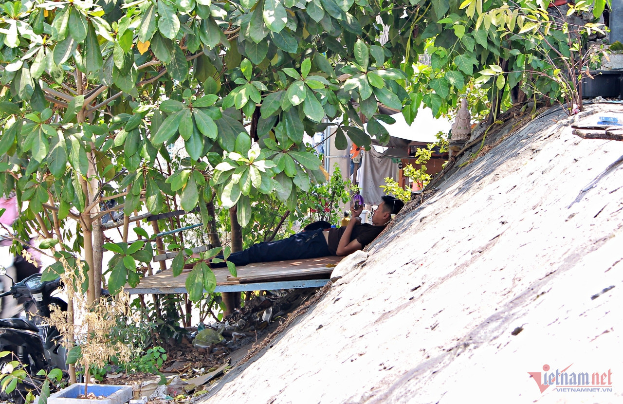 Nắng nóng vượt mức chịu đựng, nam thanh niên bỏ phòng trọ ra nằm trên chiếc giường tự chế dưới gốc cây bàng râm mát. Ảnh: Hà Nguyễn. Nắng nóng vượt mức chịu đựng, nam thanh niên bỏ phòng trọ ra nằm trên chiếc giường tự chế dưới gốc cây bàng râm mát. Ảnh: Hà Nguyễn.