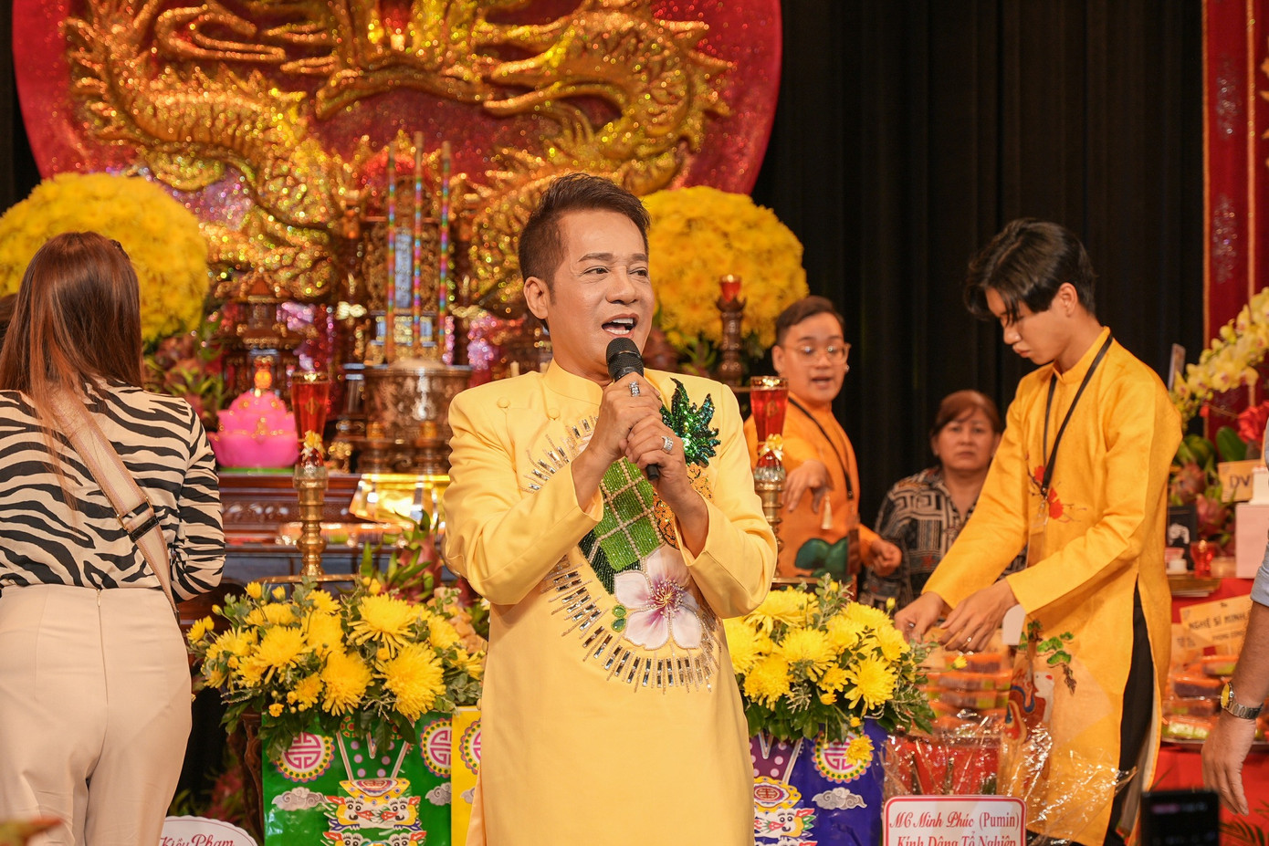 Sân khấu Trương Hùng Minh của nghệ sĩ Minh Nhí tổ chức giỗ Tổ trang trọng với màu vàng chủ đạo. Nam nghệ sĩ diện áo dài trang trọng đón khách.