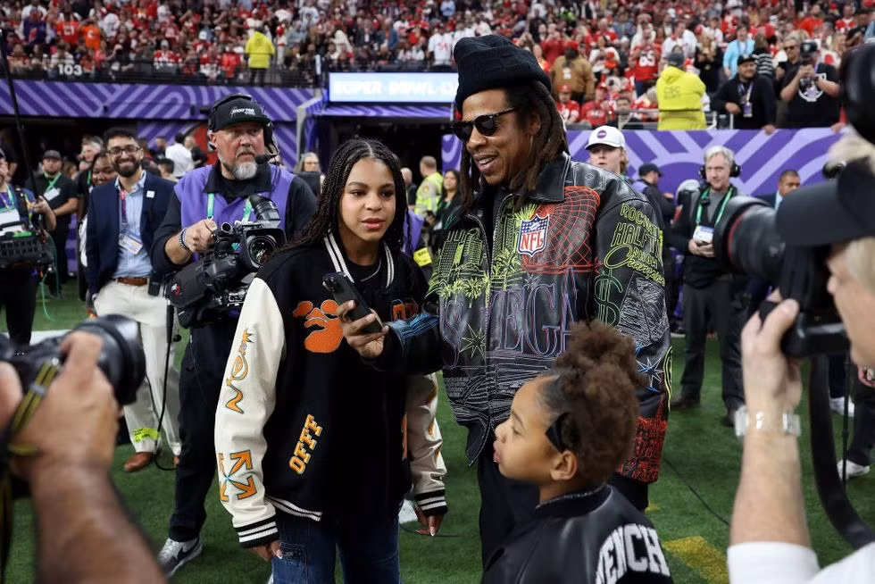 Jay-Z đưa Blue Ivy và Rumi xuống sân bóng giao lưu ống kính. Nam rapper mặc phong cách hip hop đồng điệu cùng hai con. Jay-Z đưa Blue Ivy và Rumi xuống sân bóng giao lưu ống kính. Nam rapper mặc phong cách hip hop đồng điệu cùng hai con.