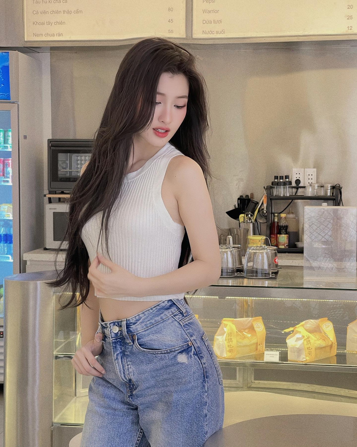 Á hậu Phương Nhi được nhận xét phù hợp nhiều phong cách. Thiết kế áo ba lỗ chất liệu thun gân phối cùng quần jeans bó mang lại cảm giác thập niên 1970.