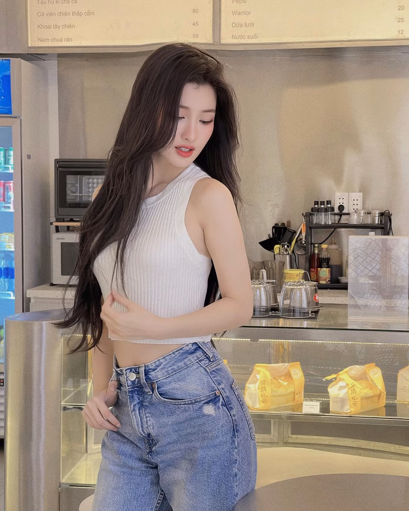 Á hậu Phương Nhi được nhận xét phù hợp nhiều phong cách. Thiết kế áo ba lỗ chất liệu thun gân phối cùng quần jeans bó mang lại cảm giác thập niên 1970.