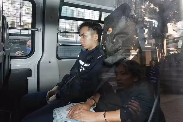 Lin bị trùm đầu khi bị áp giải ra tòa.