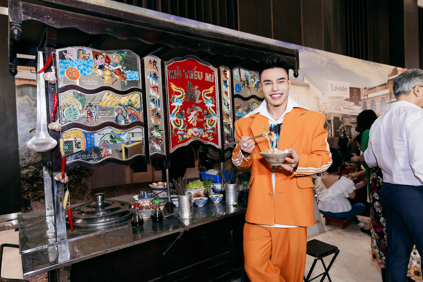 Lê Dương Bảo Lâm mặc trang phục nổi bật dự show của Đàm Vĩnh Hưng. Nam diễn viên tạo dáng trước xe hủ tiếu đậm phong cách Sài Gòn.