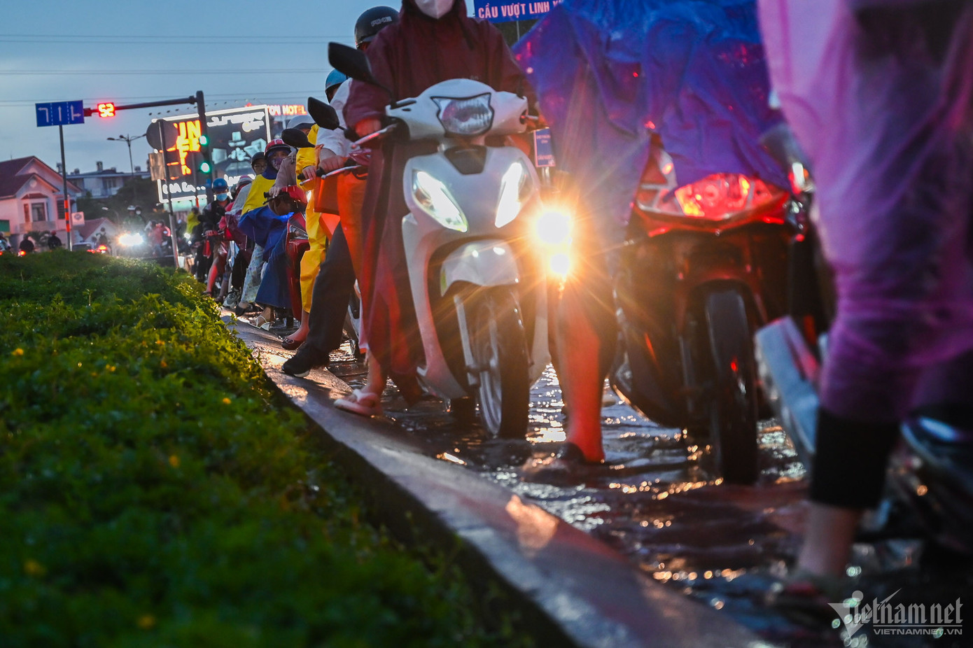 Người dân vất vả nối đuôi nhau trong làn nước ngập.