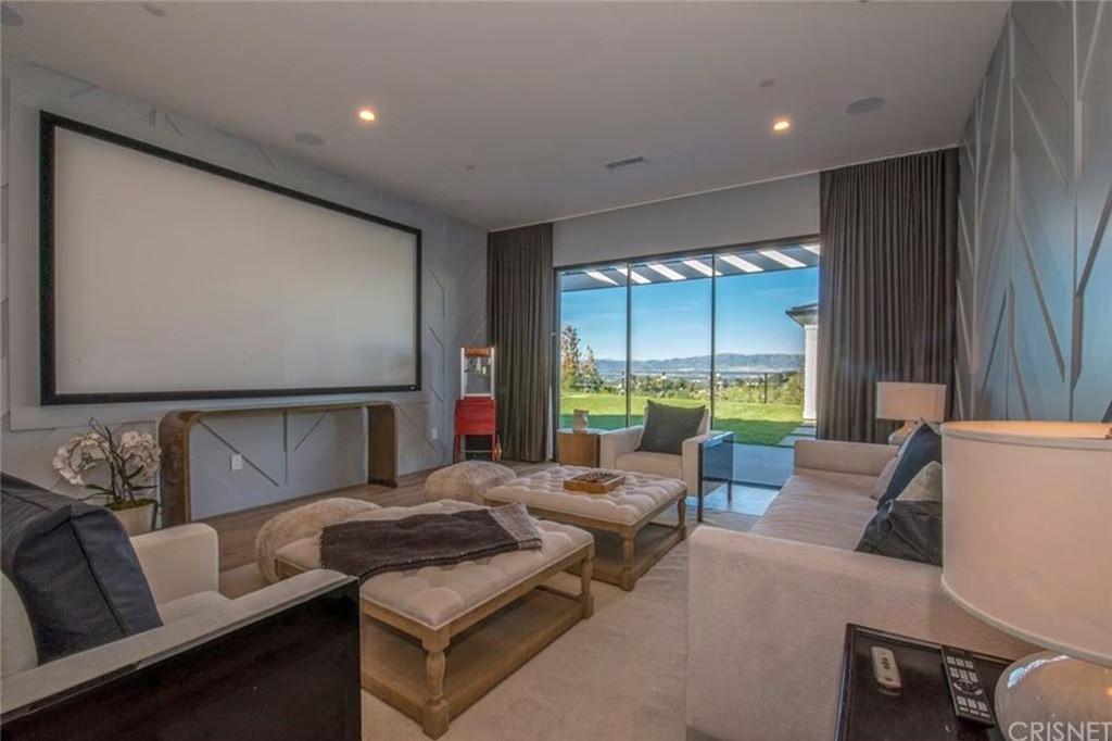 Phòng xem phim riêng với màn hình lớn, hướng nhìn ra sân sau và bãi cỏ lớn.