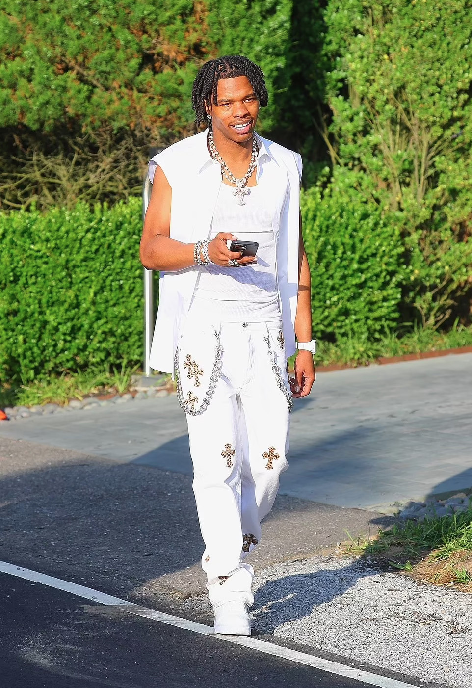 Rapper Lil Baby đến dạ tiệc trắng với trang phục đậm chất hip-hop. Nam ca sĩ gây ấn tượng với phụ kiện dây chuyền bạc bản to in hình thập tự, họa tiết Thánh giá trên trang phục.