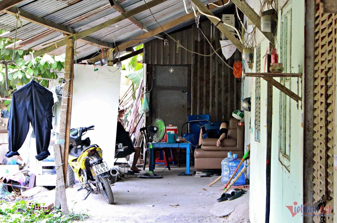Tại dãy trọ chật hẹp, có mái lợp bằng tôn tại Xóm Củi, nhiều người cũng rời khỏi phòng, ra ngồi, nằm ở nơi có bóng mát cây xanh. Ảnh: Hà Nguyễn. Tại dãy trọ chật hẹp, có mái lợp bằng tôn tại Xóm Củi, nhiều người cũng rời khỏi phòng, ra ngồi, nằm ở nơi có bóng mát cây xanh. Ảnh: Hà Nguyễn.