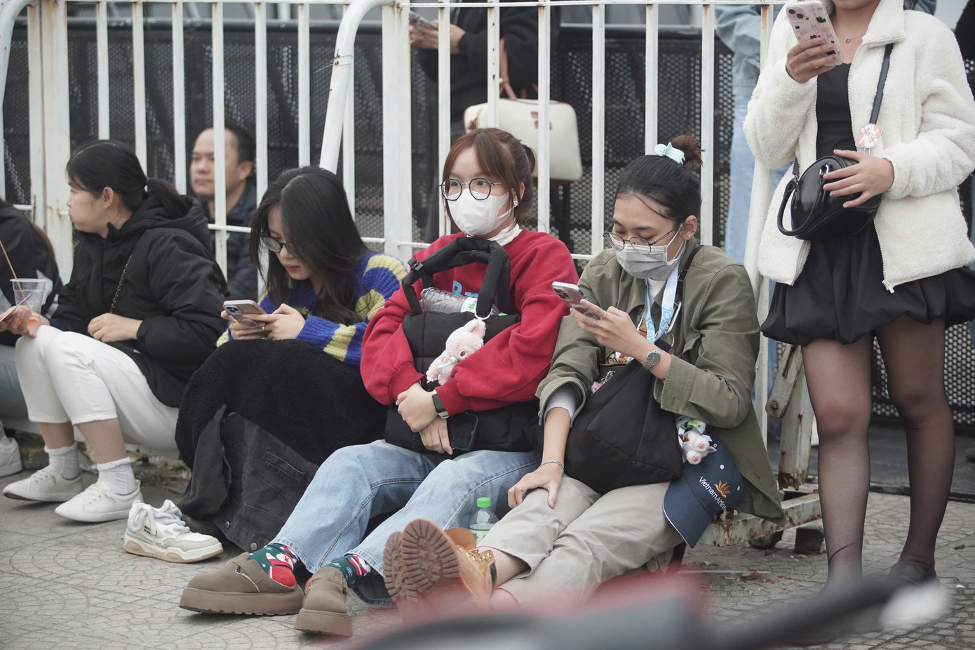 Theo ghi nhận của Tiền Phong, sân vận động Mỹ Đình đang có gió lớn. Nhiều người mặc ấm, ngồi co ro quanh khu vực hàng rào.