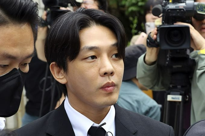 Yoo Ah In bị còng tay ra tòa hồi tháng 5.