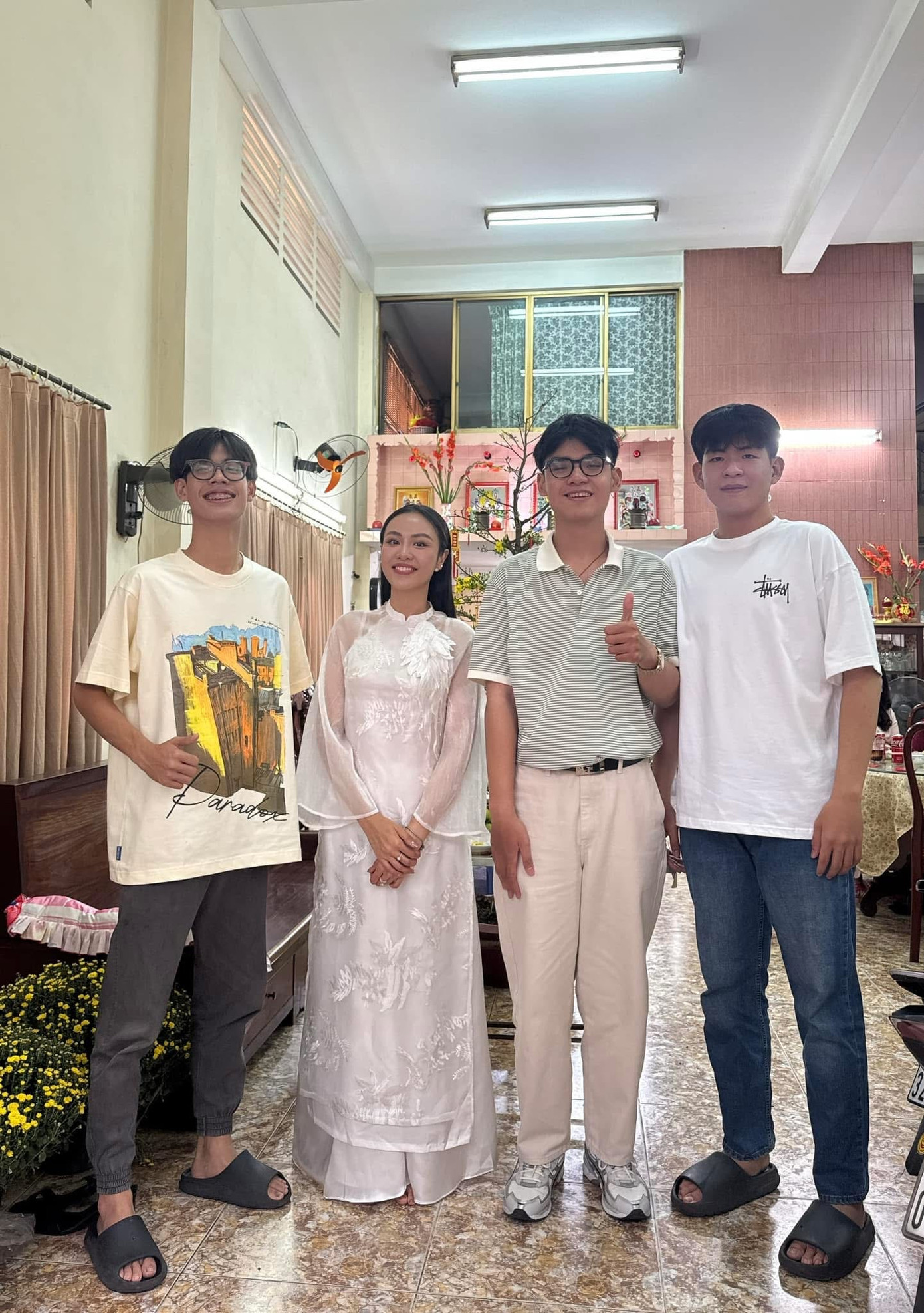 Á hậu Thủy Tiên "lọt thỏm" bên các em trai. "Nhỏ con nhất nhà. Các em hồi đó nhỏ xíu, giờ đã 1,8 m, 1,9 m hết rồi", cô viết.