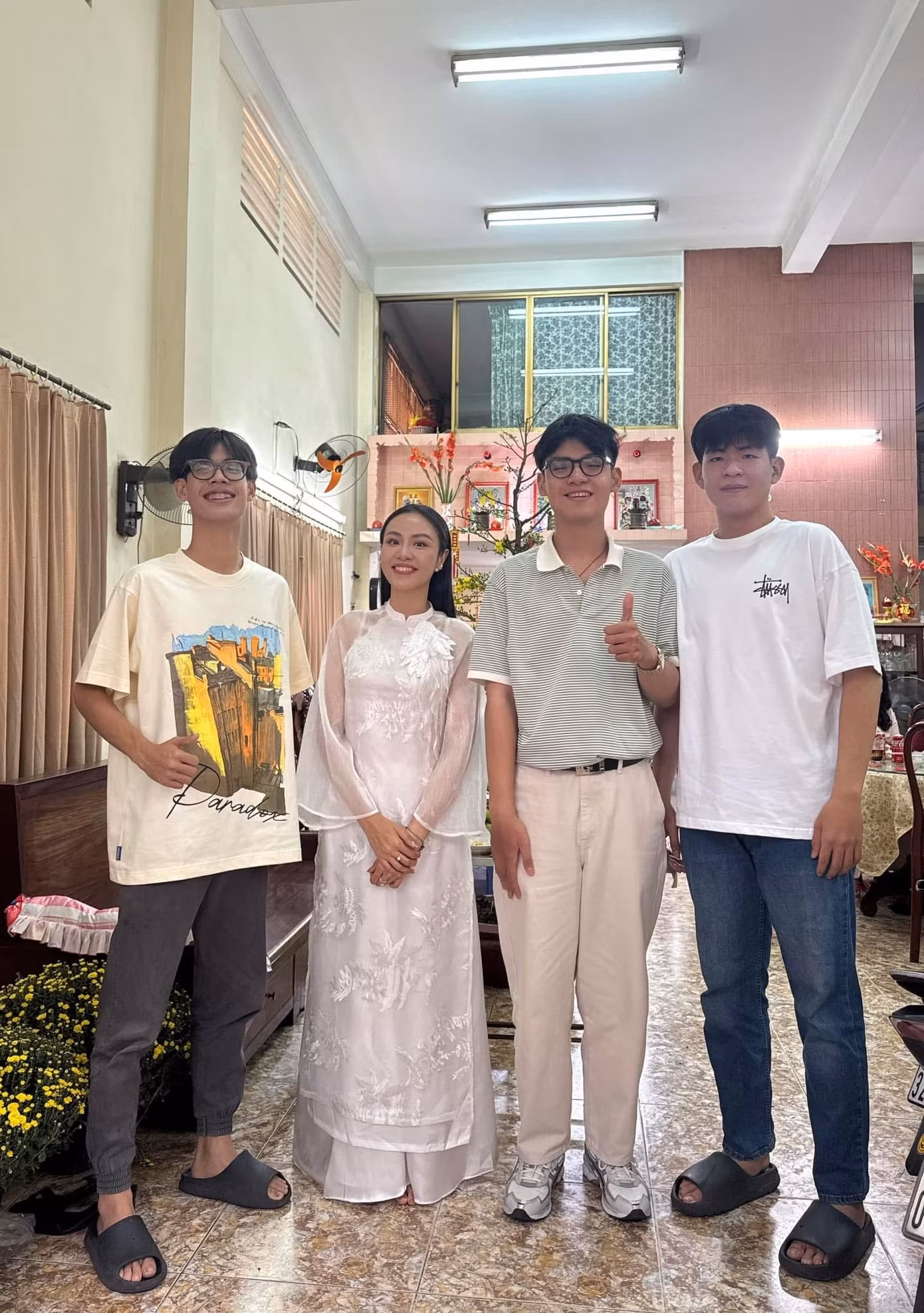 Á hậu Thủy Tiên "lọt thỏm" bên các em trai. "Nhỏ con nhất nhà. Các em hồi đó nhỏ xíu, giờ đã 1,8 m, 1,9 m hết rồi", cô viết.