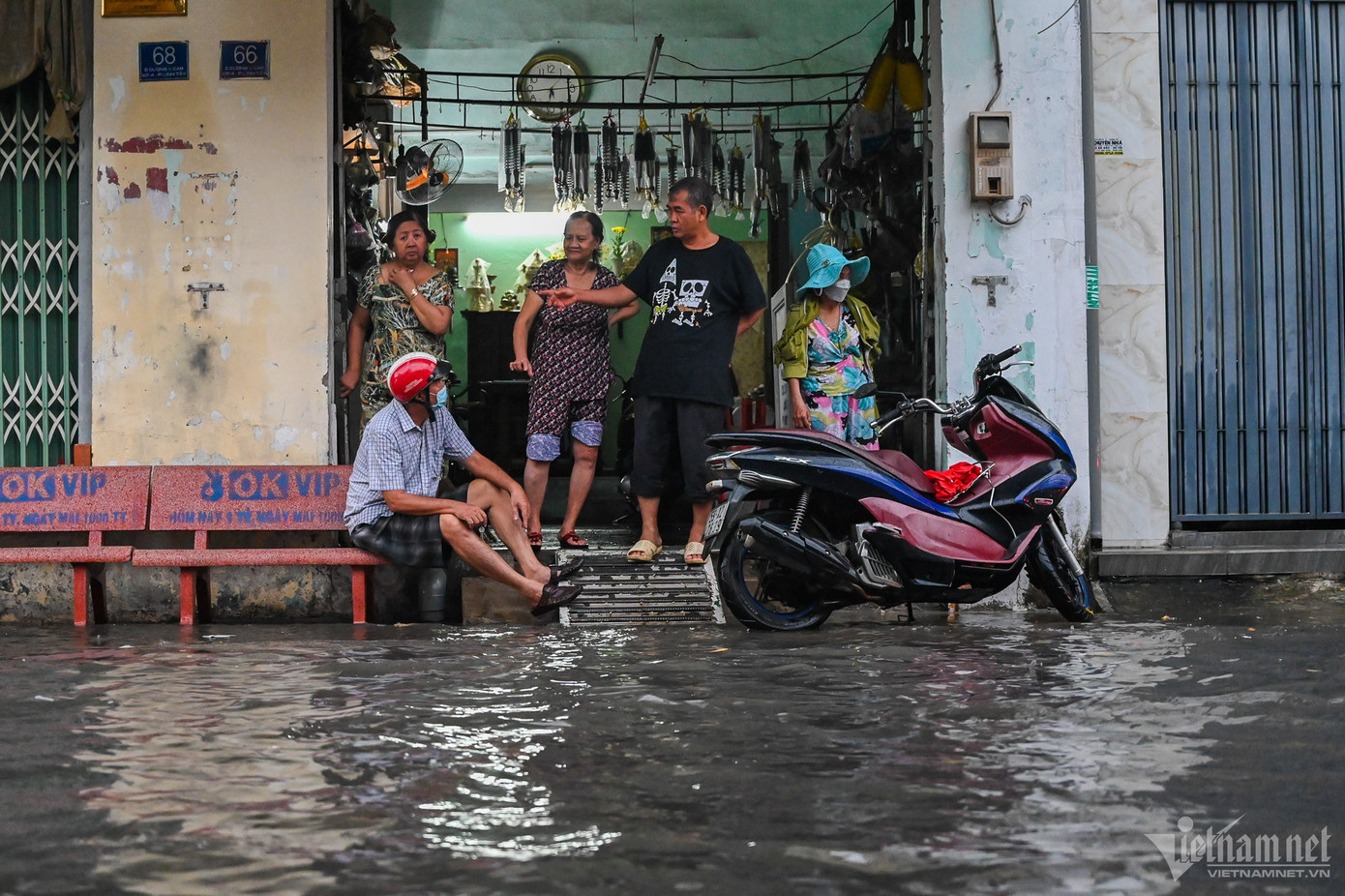 Một người đàn ông phải dựng xe lên vỉa hè ngồi chờ nước rút rồi mới rời đi.