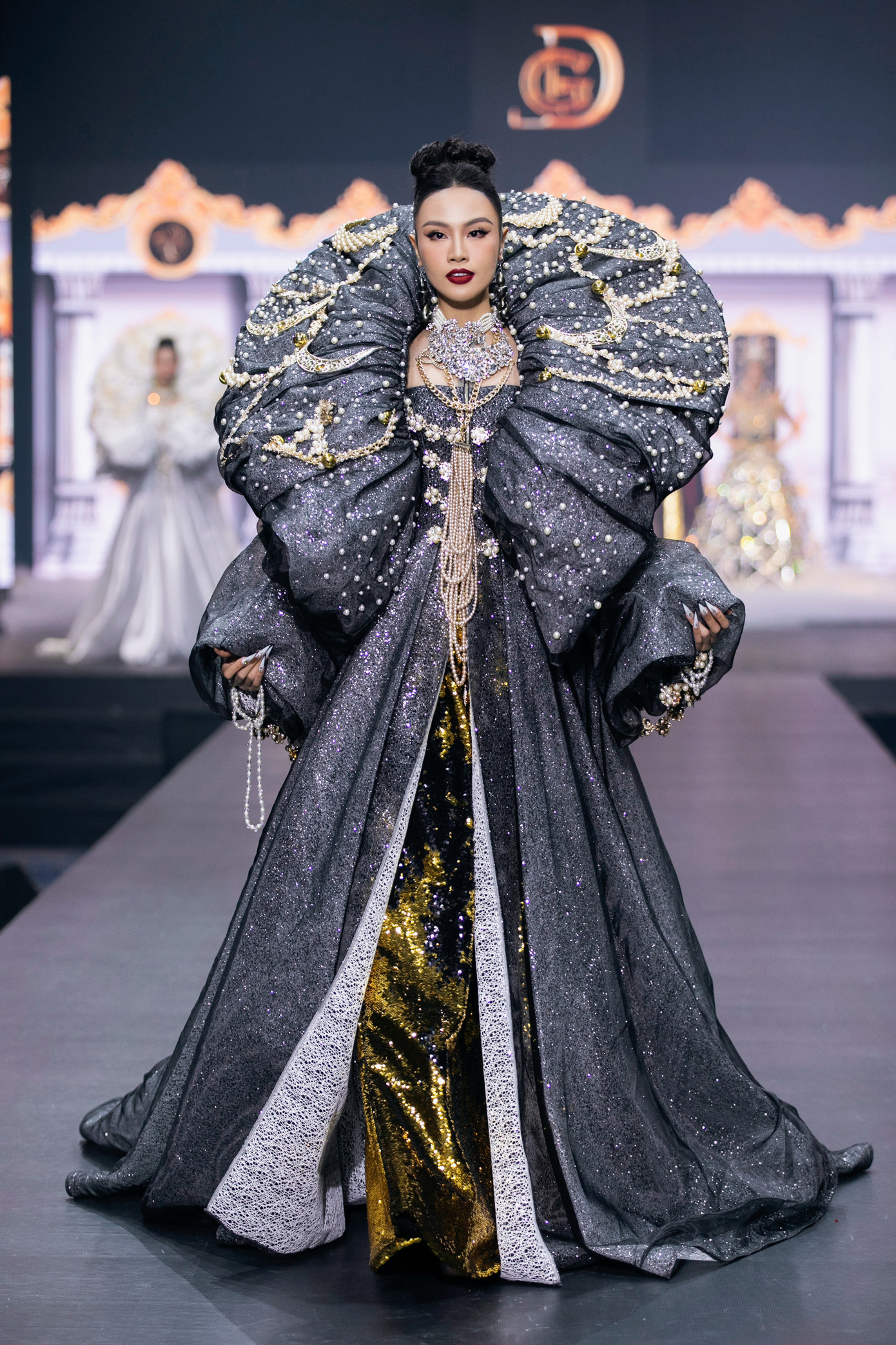 Trang phục của Á hậu Thủy Tiên có phom dáng tương tự thiết kế mà Phương Khánh trình diễn. Thiết kế đen đính ngọc trai làm người xem liên tưởng trang phục của hoàng hậu, quý tộc châu Âu.