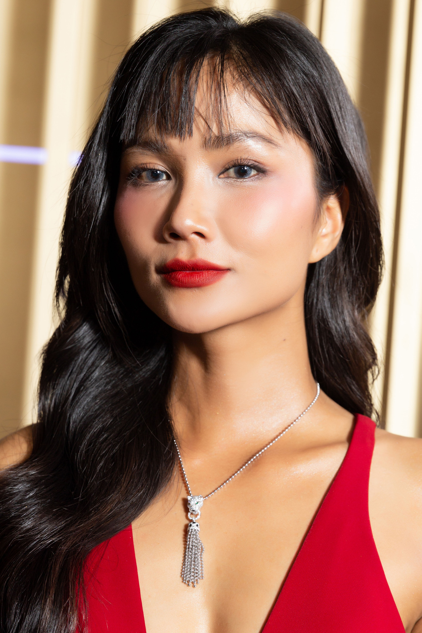 H&apos;Hen Niê chọn lối trang điểm đậm khi diện váy đỏ khoét sâu táo bạo. Cô chọn phụ kiện tối giản để tăng vẻ sang trọng.