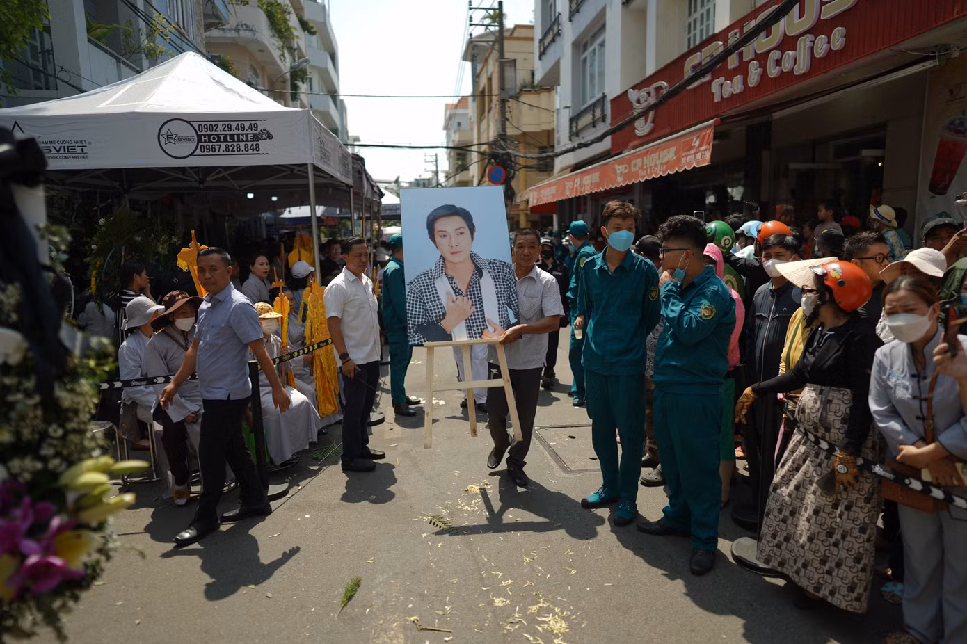 Người thân cầm di ảnh của cố NSƯT Vũ Linh. Hai bên đường, người dân đứng chỉnh tề chờ tiễn đưa Vũ Linh.