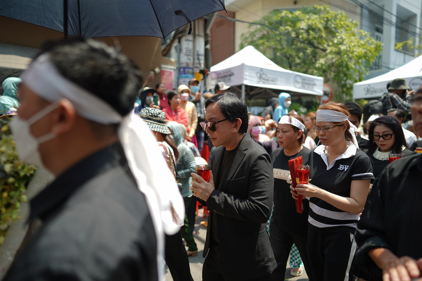 NSƯT Kim Tử Long tranh thủ đến sớm đưa tiễn đàn anh. Đêm qua, nam nghệ sĩ và NSƯT Ngọc Huyền đến tang lễ muộn do vướng lịch diễn ở Tây Ninh. Đi sau là chị Nga - người bên cạnh chăm sóc cho Vũ Linh suốt 10 năm cuối đời.