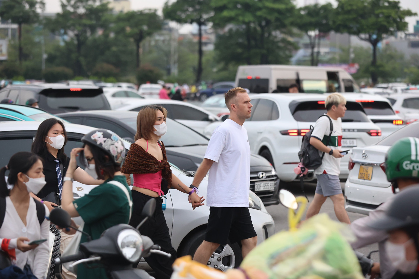 Người đi bộ băng qua dòng xe để vào sân vận động.