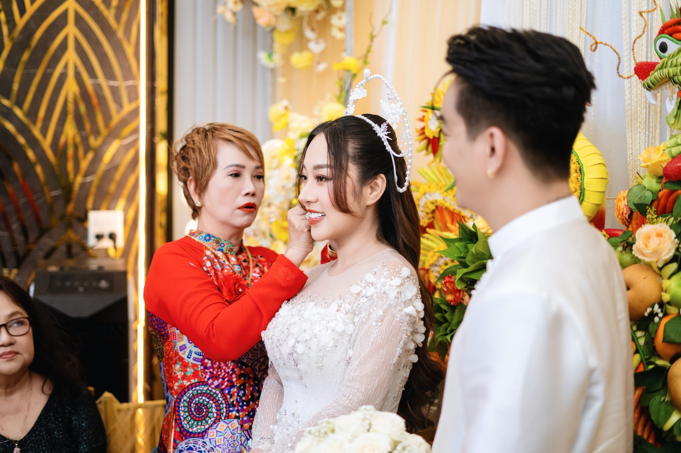 Khoảnh khắc mẹ chồng đeo trang sức cho con dâu. Tuyết Nhung nhận được quà cưới là hoa tai, dây chuyền, nhẫn kim cương, tiền mặt 10.000 USD, ba cây vàng 9999 từ mẹ chồng.