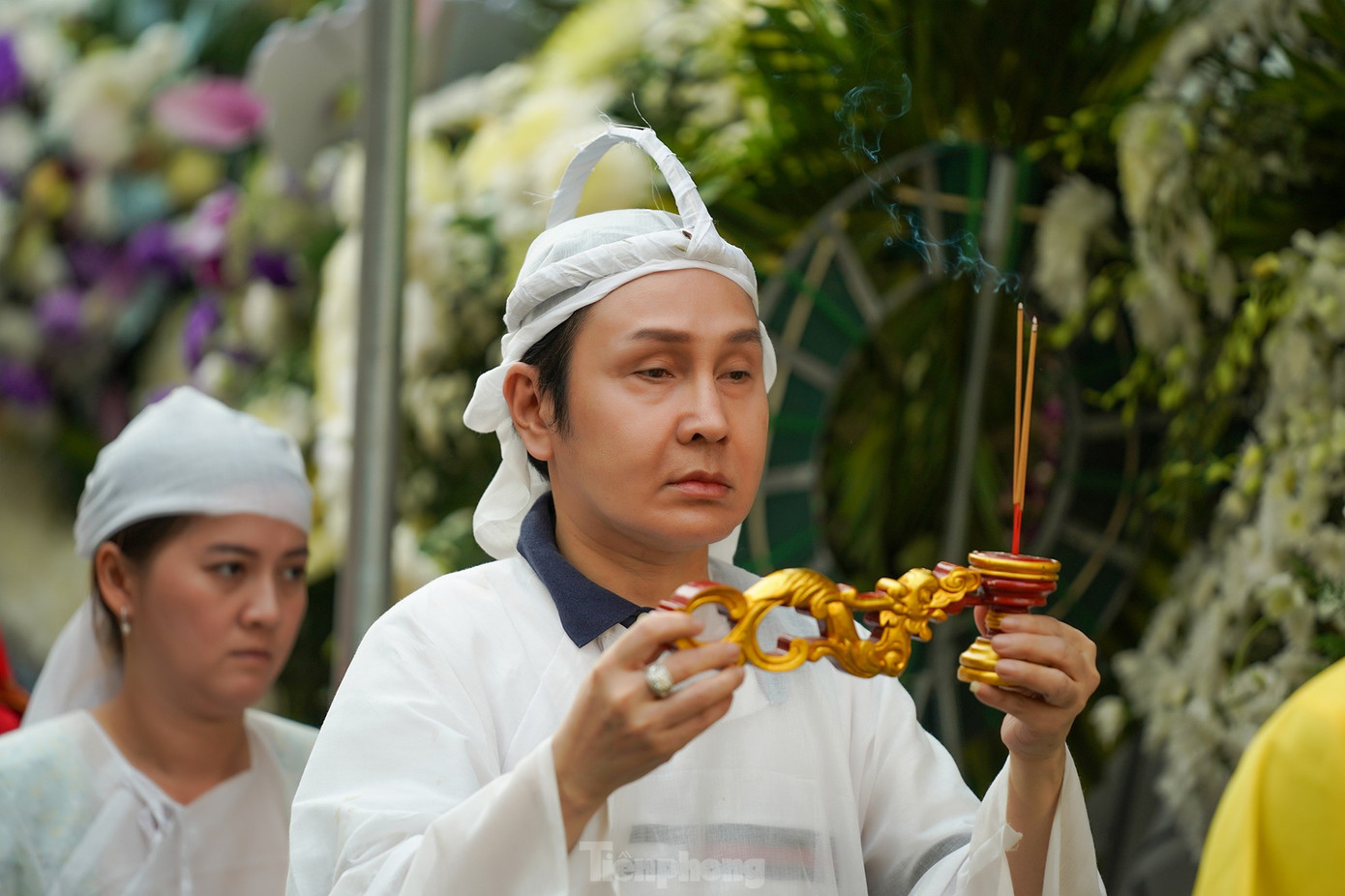 NSƯT Vũ Luân - con nuôi của Vũ Linh - và Hồng Loan (phía sau, người con gái của Vũ Linh) thực hiện nghi thức cúng cha. Gương mặt hai người con của ông hoàng cải lương tuồng cổ lộ rõ vẻ tiều tụy trước sự ra đi của NSƯT Vũ Linh. Ảnh: Phạm Nguyễn. NSƯT Vũ Luân - con nuôi của Vũ Linh - và Hồng Loan (phía sau, người con gái của Vũ Linh) thực hiện nghi thức cúng cha. Gương mặt hai người con của ông hoàng cải lương tuồng cổ lộ rõ vẻ tiều tụy trước sự ra đi của NSƯT Vũ Linh. Ảnh: Phạm Nguyễn.